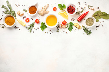 Herbs and spices over light stone background. Top view. Copy space