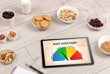 Healthy food with tablet on a wooden background with words Body Mass Index. Health concept.