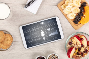 Healthy food composition with tablet. Body diagnosis on the screen