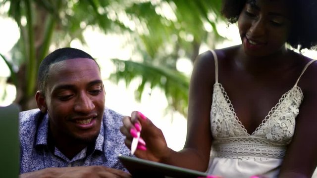 Young Black Couple Using Technology in the Park. Laptop, Tablet, phone. Miami beach Florida US