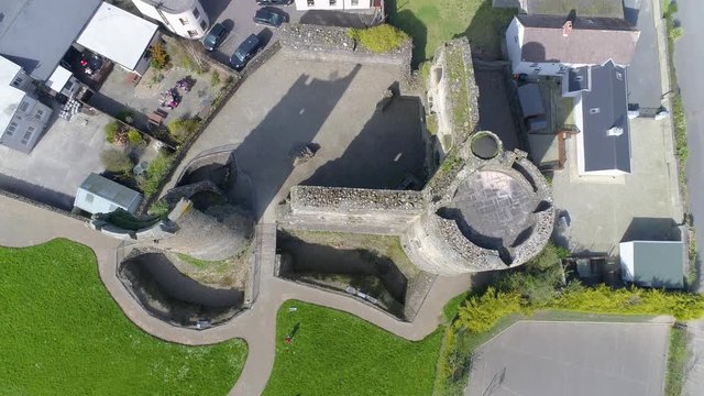 4K aerial bird's eye view of old Irish castle in Wexford. Town of Ferns revealed in the background.