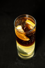 Cuba Libre cocktail with rum, coke and lime juice with lime wedge and full of ices
