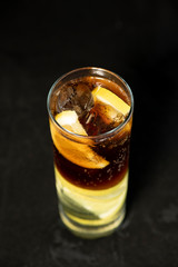 Cuba Libre cocktail with rum, coke and lime juice with lime wedge and full of ices