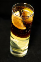 Cuba Libre cocktail with rum, coke and lime juice with lime wedge and full of ices