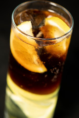 Cuba Libre cocktail with rum, coke and lime juice with lime wedge and full of ices