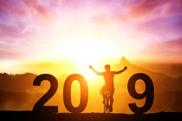 Papier Peint photo Vélo Vélo de silhouette dans le texte de 2019 sur le coucher du soleil, amitié dans le sport de vélo. bonne année