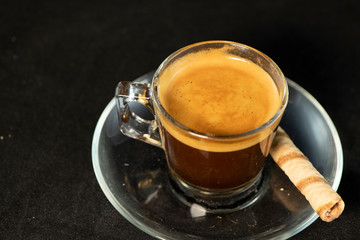 Double espresso and wafer roll with black background