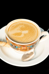 Vanilla latte coffee with wafer rolls with isolated black background