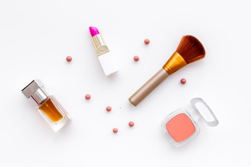 Set of pink cosmetics. Lipstick, bulk, eyeshadow, perfume near brushes on white background top view