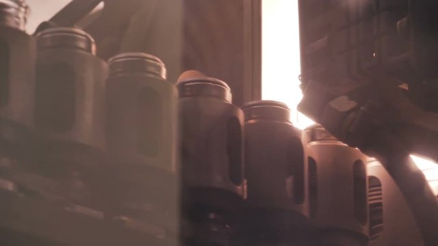 Plastic preform bottles move through the machine for blowing