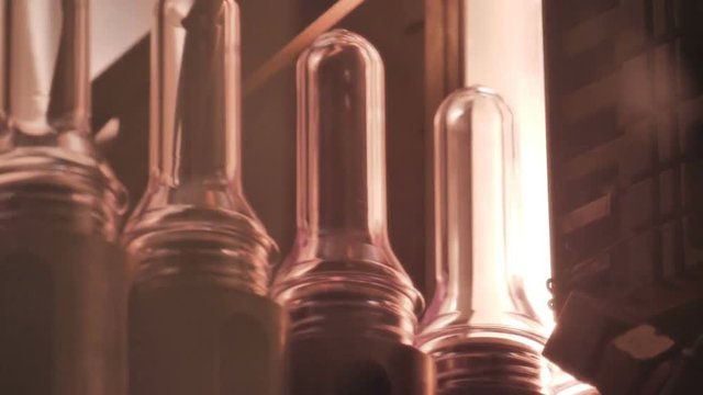 Plastic preform bottles move through the machine for blowing