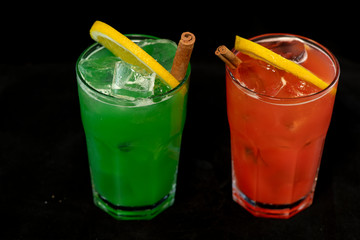 Red and Green Cocktails with red and green juices, alcohol and lime wedge