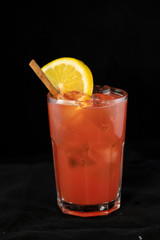 Red Cocktail with red juices, alcohol and lime wedge
