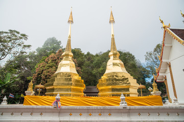 Fototapeta premium Wat Phra That Doi Tung an iconic twin ancient pagoda on Doi Tung mountain of Chiang Rai province of Thailand in winter season.