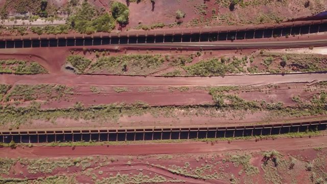 An overhead, top-down, shot of two iron ore trains passing each other in the Pilbra region of Western Australia.