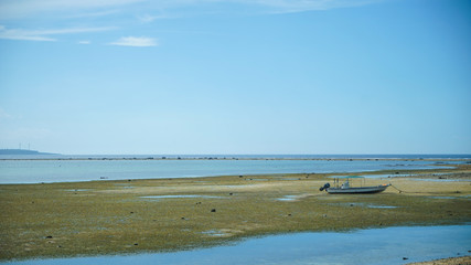 The boat was left on the beach and blue sky