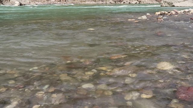 Peaceful Ganga river in Himalayas with green water on a pleasant day and sand on the banks of the River.