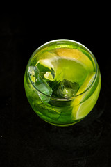 Green cocktail with gin, bitter lemon, basil and lemon