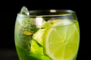 Green cocktail with gin, bitter lemon, basil and lemon