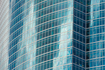 Abstract architecture of a modern building turquoise colored glass facade.