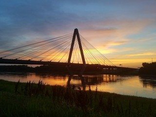 Sunset through the bridge over the water