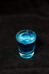 Jellyfish shot cocktail with blue curacao, sambuca, vodka and milk