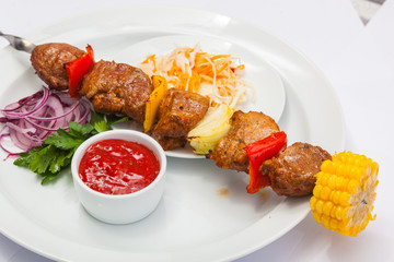 shashlik on skewer with red sauce