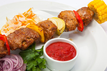 shashlik on skewer with red sauce
