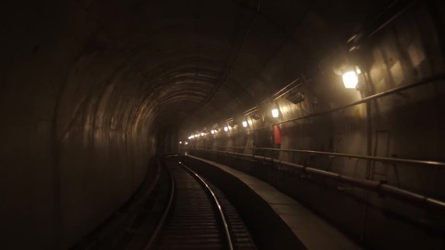 View of subway tunnel as seen from reverse of moving backward train. Fast underground train riding in tunnel of modern city. Underground train in Milan following its route