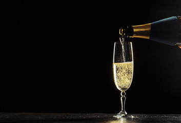 bottle of champagne and glasses over dark background © fotofabrika