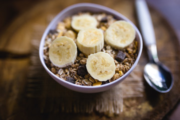 Bowl of cereal with fruit, pieces of banana with oats and cereal.