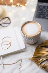 Lady bloggers white work space with gold details, laptop and cof