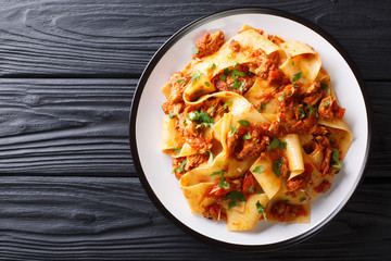 Italian Taccozzette con Stracotto pasta with slow cooked pork in a spicy sauce close-up on a plate. Horizontal top view