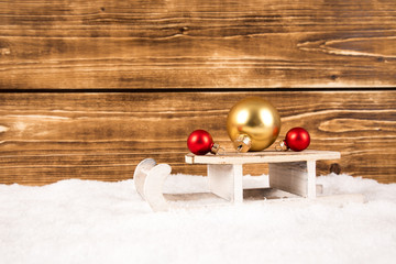 sleigh with christmas balls on a wooden background