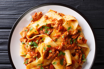 Pasta with Braised Pork Shoulder Ragu close-up on a plate on the table. Horizontal top view