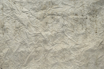 darkness theme. dark background and wallpaper or texture of paper old and crumpled have a stain in shades of gray.