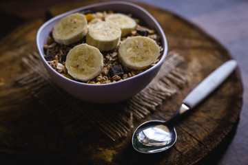 Bowl of cereal with fruit, pieces of banana with oats and cereal.
