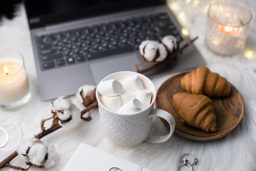 Cozy winter bloggers white work space with laptop, coffee with m