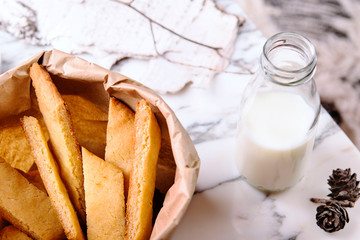 Kolakakor - swedish cookies, bottle of milk and candle and pine cone on grey marble table. Fast and easy scandinavian pastry. Cozy winter treat. Hygge. Fika