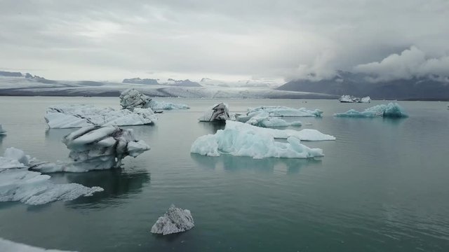 A drone footage of a boat in between the icebergs