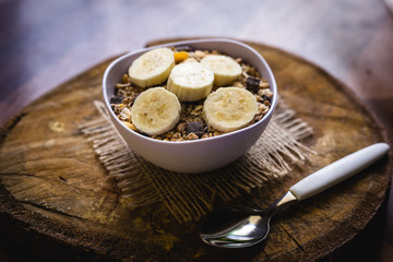 Bowl of cereal with fruit, pieces of banana with oats and cereal.