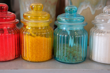 brown rock sugar in red yellow blue glass jar pot