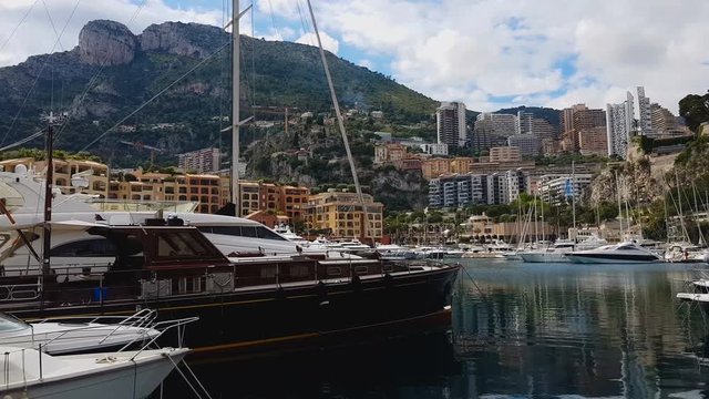 Seaport with yachts and boats under mountain, holidays in small resort town