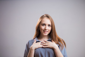 Touching moment. Charming young student girl smiling, surprised, happy news, birthday gift or new year and hands applied to the chest. Human emotions, facial expression, happiness