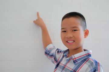little asian kid boy child children schoolboy smiling & pointing up