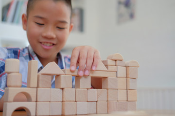 little asian kid boy child children schoolboy playing wood block toy. learning education concept