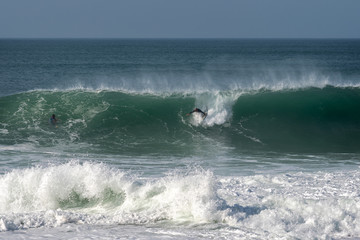 Surfer on Atlantic ocean wave , Nazare , Portugal.