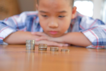 asian kid boy child children with coins stack pile. money savings cash deposit for future