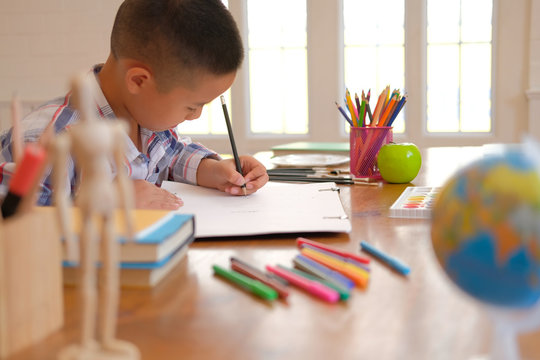 asian kid boy child schoolboy drawing picture. children activity at home