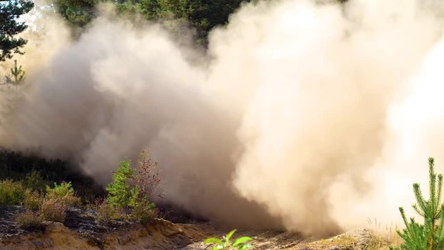 A rally car speeding through a dusty track leaving a cloud of dust.